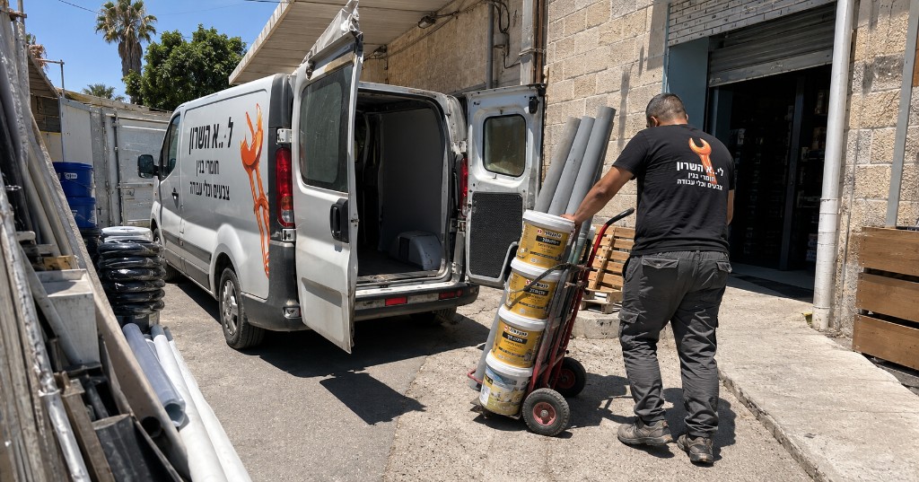 טעינת חומרי בניין לרכב משלוח — דלי צבע, צנרת ועגלה מקצועית לשטח העבודה טעינת חומרי בניין לרכב משלוח — דלי צבע, צנרת ועגלה מקצועית לשטח העבודה
